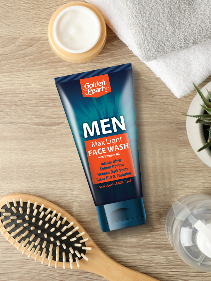 Tube of Golden Pearl Men Max Light Face Wash on a wooden surface with a brush and towel in the background.
