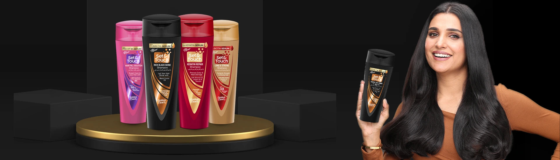 Woman with long black hair holding a hair product with hair care products displayed on a stand.